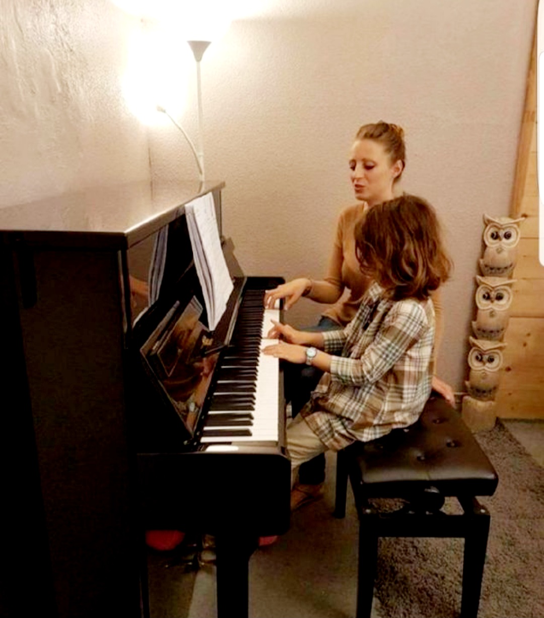 Marie donnant un cours de piano à un enfant